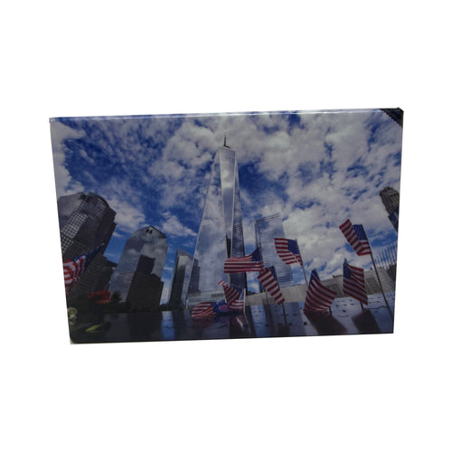 Magnet with the Freedom Tower and American Flags in the forefront both against a cloudy blue sky.
