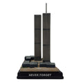A collectible model of the Twin Towers, featuring the two skyscrapers on a  brown base with the inscription 'NEVER FORGET' on the front.