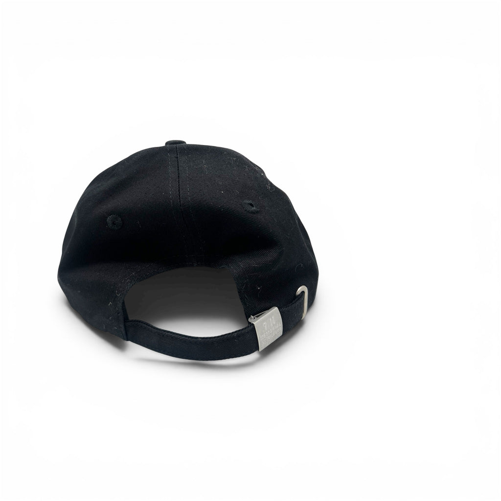 A black baseball cap shown from the back, featuring a black fabric crown, matching black eyelets, and an adjustable black strap with a silver metal slider, set against a plain white background.
