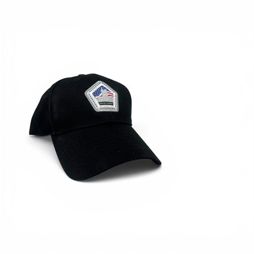 A black baseball cap with a small embroidered pentagonal patch on the front featuring an American flag and the text 'Never Forget'.