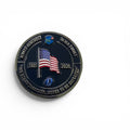 A round commemorative coin on a plain white background. The coin has an enamel face with an American flag, the years 2001 and 2026, and curved text around the edge including 'ALWAYS REMEMBER' and 'NEVER FORGET'.