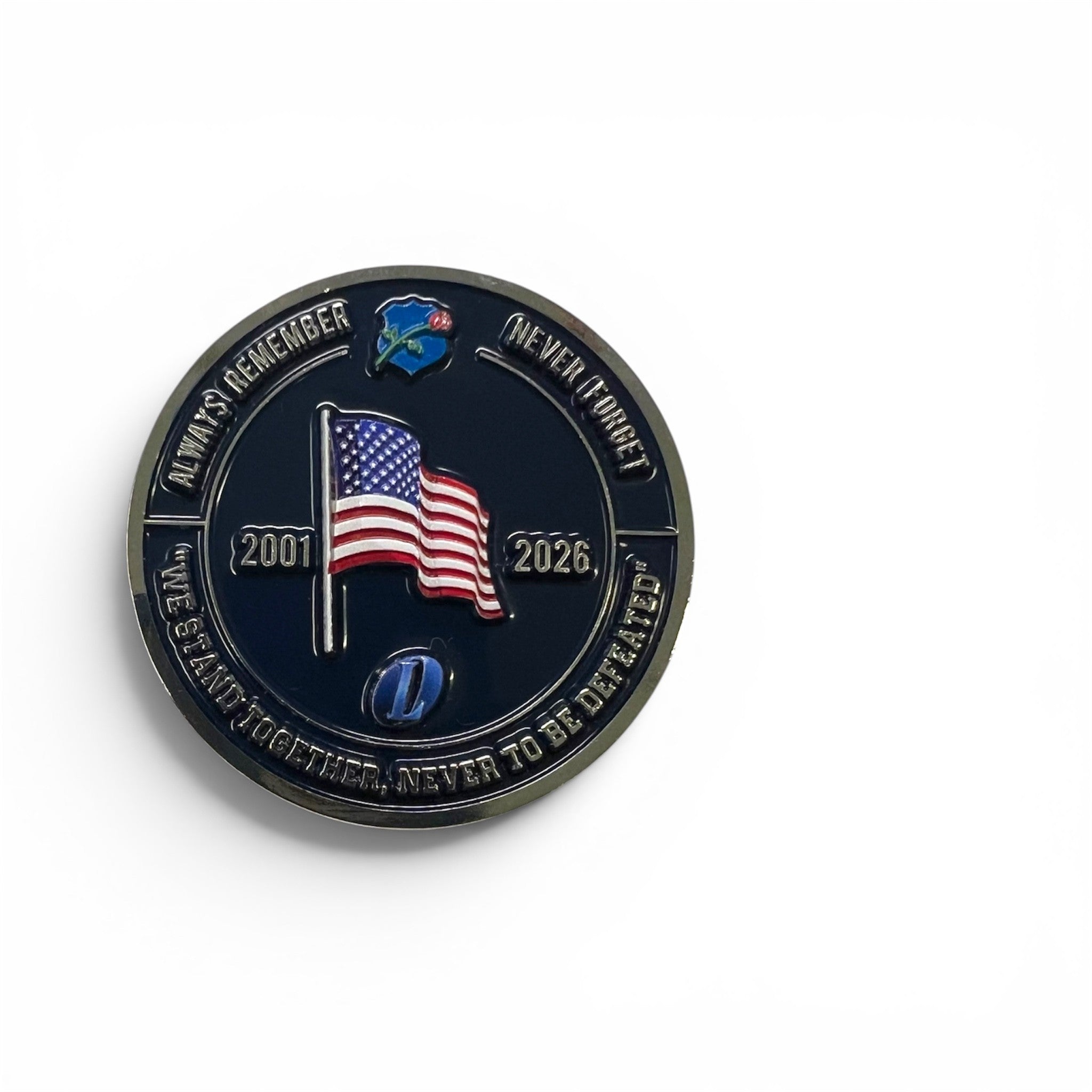 A round commemorative coin on a plain white background. The coin has an enamel face with an American flag, the years 2001 and 2026, and curved text around the edge including 'ALWAYS REMEMBER' and 'NEVER FORGET'.