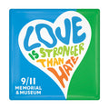 Colorful heart-shaped sign with 'Love is Stronger than Hate' text on a blue and green background, featuring the 9/11 Memorial & Museum logo.