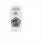 A pentagonal commemorative magnet displayed on its white retail backing card, photographed against a clean white background. The magnet features a detailed graphic of the Twin Towers with the American flag and the text 'NEVER FORGET' and 'SEPTEMBER 11, 2001'.