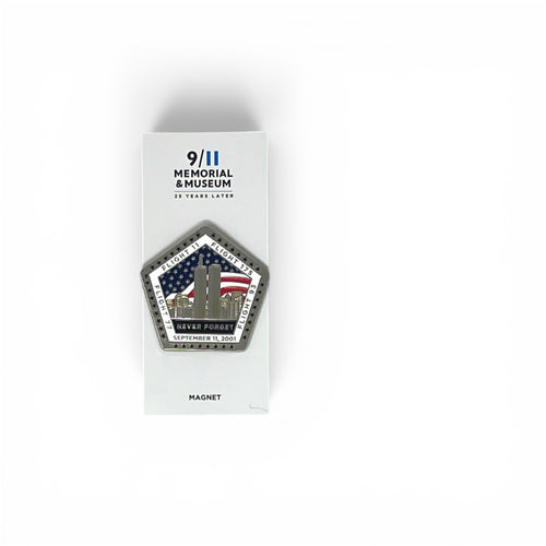 A pentagonal commemorative magnet displayed on its white retail backing card, photographed against a clean white background. The magnet features a detailed graphic of the Twin Towers with the American flag and the text 'NEVER FORGET' and 'SEPTEMBER 11, 2001'.