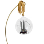 A glass keepsake ornament with a gold-colored cord, containing a miniature replica of the Twin Towers and displayed on a gold ornament holder.