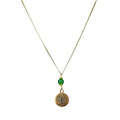 Gold-plated necklace with a round gold charm featuring a stylized tree and a small green jade stone.