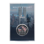 A commemorative coin with a US flag and Twin Towers design, housed in a clear display case, with 'NEVER FORGET' text on the case.