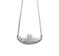 A stainless steel necklace with a skyline silhouette and the text 'NEVER FORGET 9/11' inscribed on it.