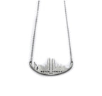 A stainless steel necklace with a skyline silhouette and the text 'NEVER FORGET 9/11' inscribed on it.