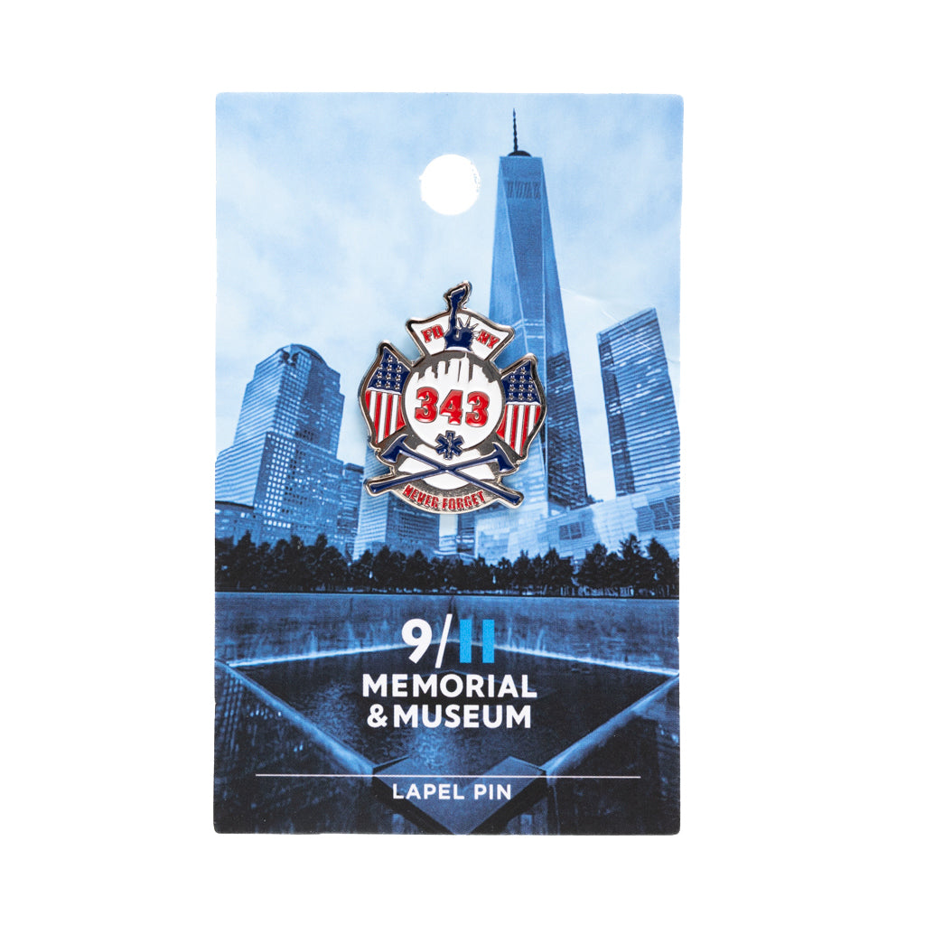 A lapel pin featuring the FDNY shield with the numbers 343, American flags, and the text 'NEVER FORGET' on a blue card backer.
