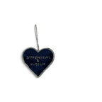 A heart-shaped dark blue memorial plaque with a silver border and hanging loop, featuring the engraved text '9/11 MEMORIAL & MUSEUM'.