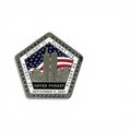 A pentagonal commemorative metal magnet featuring the Twin Towers, an American flag, and the text 'NEVER FORGET SEPTEMBER 11, 2001' on a white background.