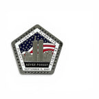 A pentagonal commemorative metal magnet featuring the Twin Towers, an American flag, and the text 'NEVER FORGET SEPTEMBER 11, 2001' on a white background.