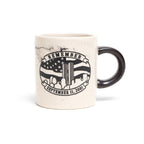 A beige ceramic mini mug with a marble-like pattern and 'REMEMBER 9/11' printed on it, featuring an American flag design.