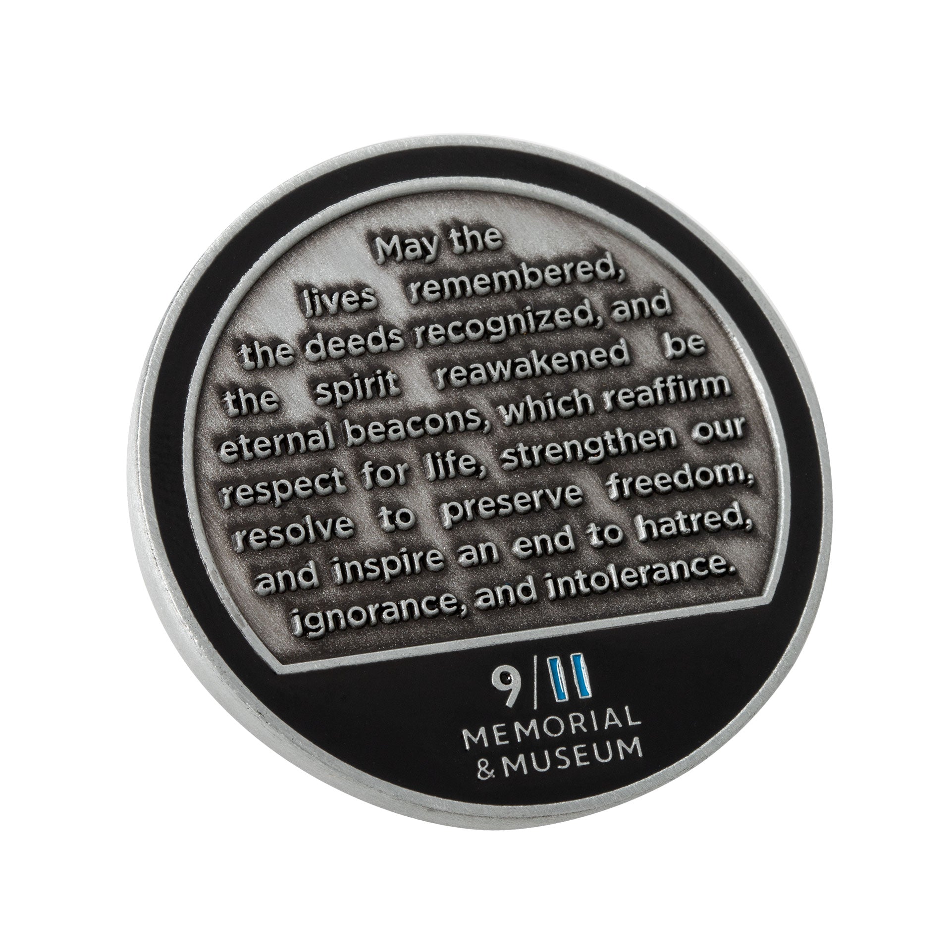 A collectible silver coin, with the words 'May the lives remembered, the deeds recognized, and the spirit reawakened be eternal beacons, which reaffirm respect for life, strengthen our resolve to preserve freedom, and inspire an end to hatred, ignorance, and intolerance.' and the 9/11 Memorial & Museum logo inscribed.
