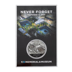 A collectible coin in a case, with the inscription 'NEVER FORGET September 11, 2001' and the logo of the 9/11 Memorial & Museum.