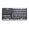 A license plate with a black and grey American flag design and the text 'NEVER FORGET 9/11' on it.
