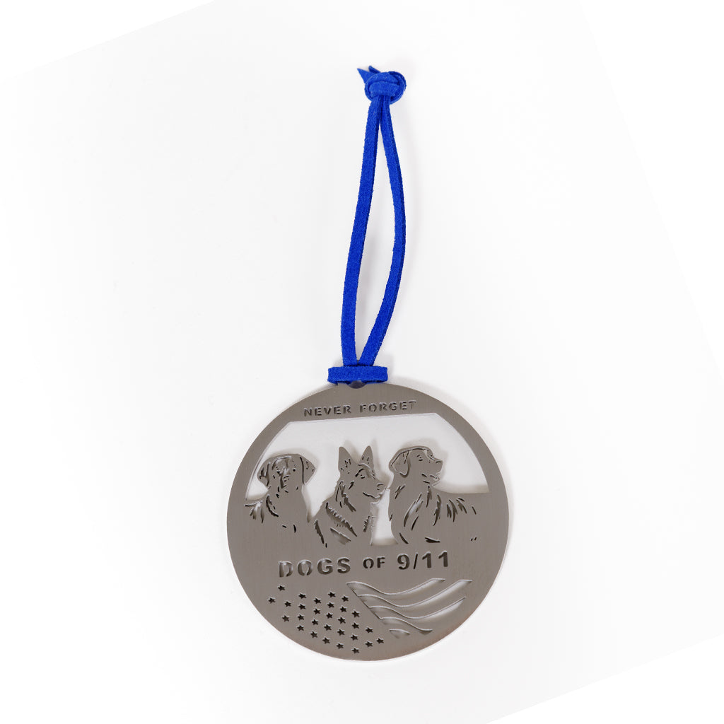 A stainless steel circular keepsake with an engraved image of three dogs and a flag with a blue ribbon attached.
