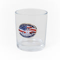 A clear water glass with a logo remembering the Twin Towers and featuring an American flag.