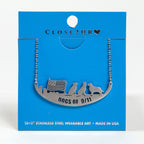 A stainless steel necklace with an engraved image of three dogs and a flag on a blue card backer.