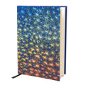 A notebook featuring a vibrant, abstract painting with star-shaped patterns in red, blue, and yellow hues.