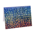 A notecard featuring a vibrant, abstract painting with star-shaped patterns in red, blue, and yellow hues.