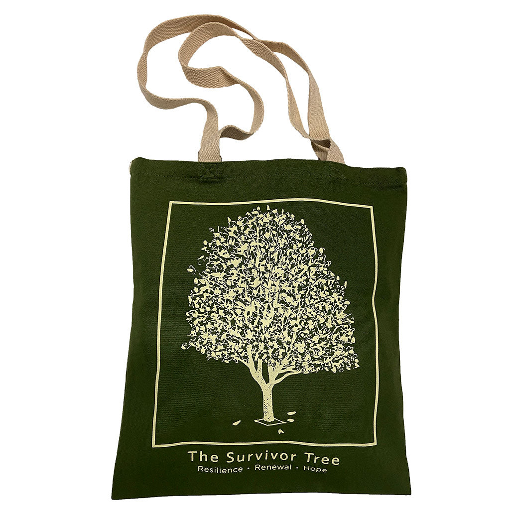 A green tote bag featuring a graphic print of the Survivor Tree and the text 'The Survivor Tree' and 'Resilience Renewal Hope".